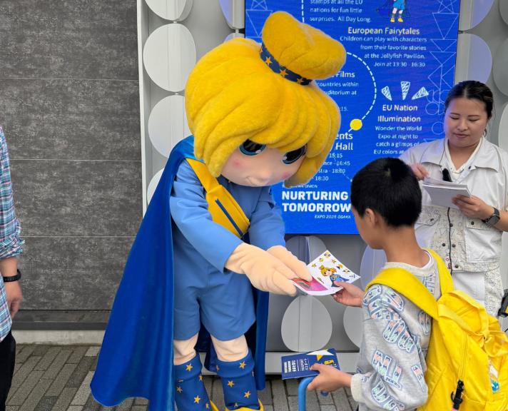 Europa mascot giving an item to a boy