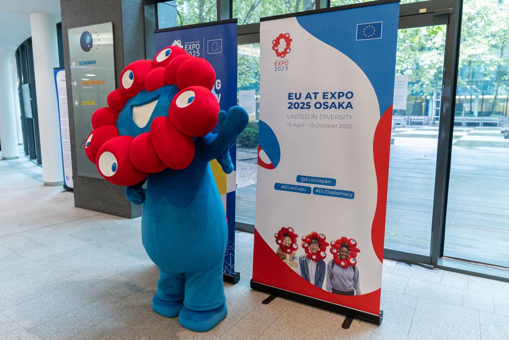 Myaku Myaku mascot in front of an Expo 2025 Osaka billboard